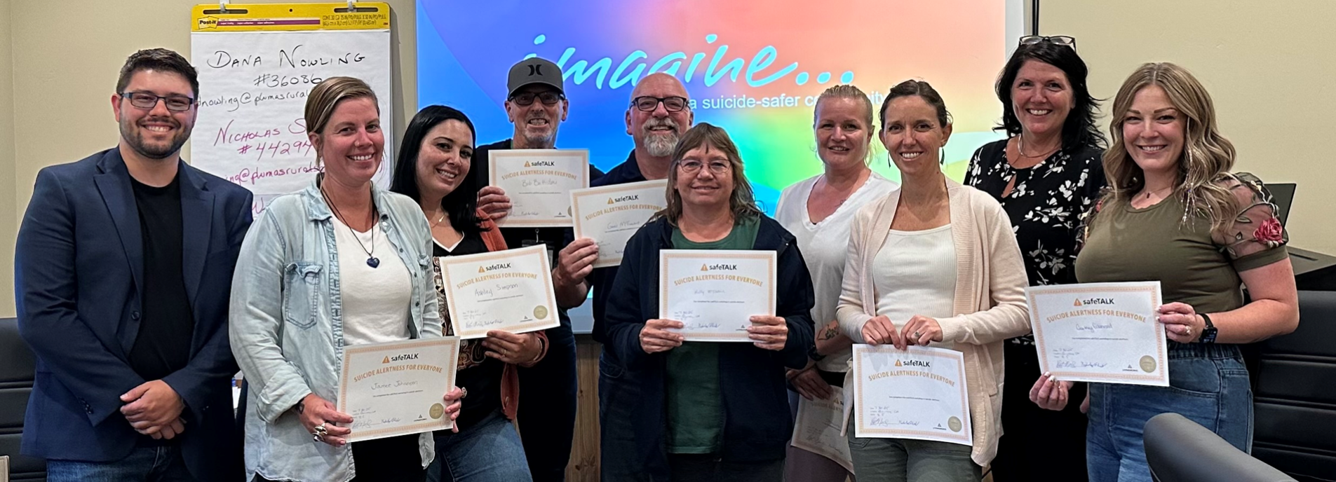Men and women holding certificate of completion of the Applied Suicide Intervention Skills Training.